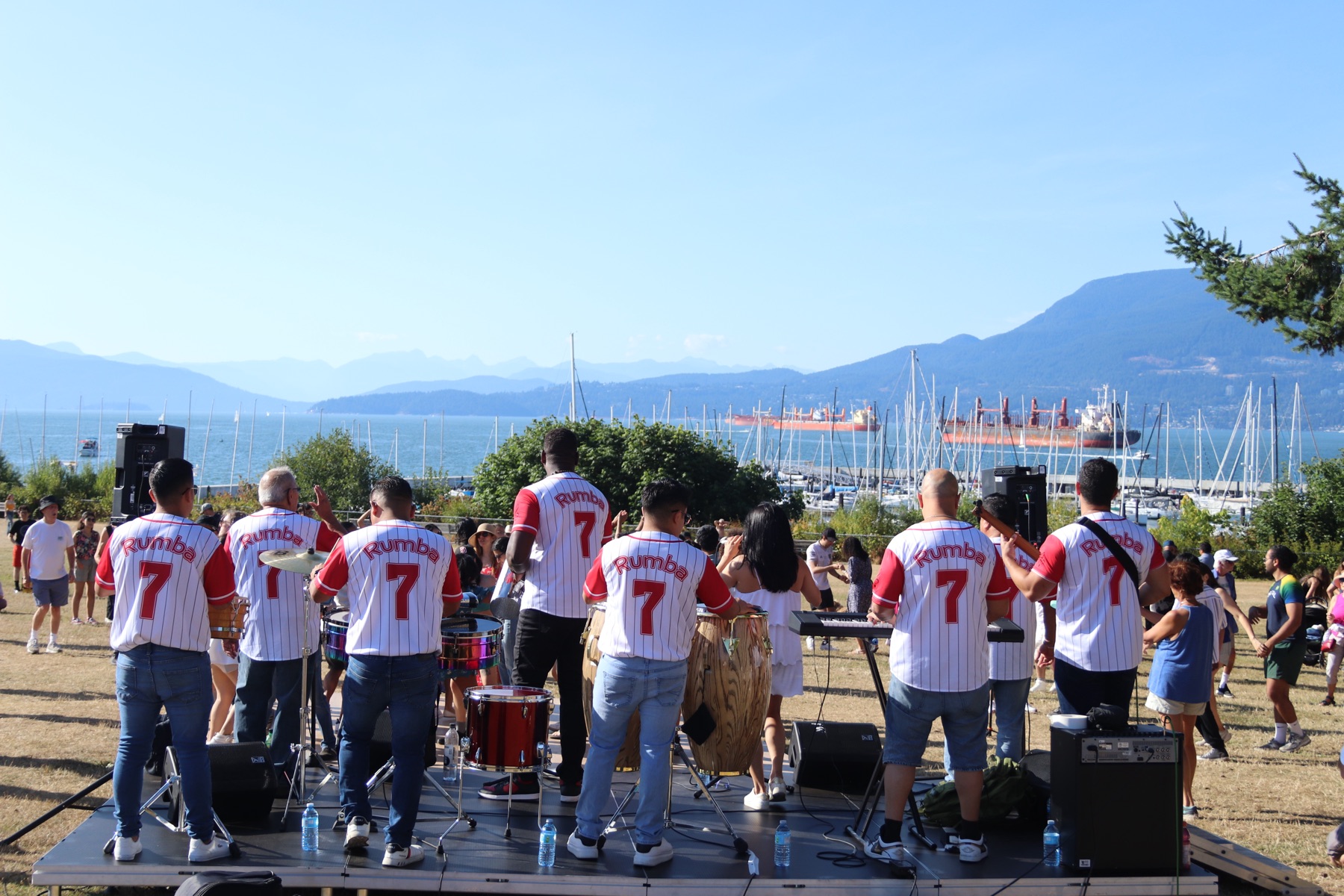 Live band playing congas, timbales, and keys on the VOSF 2025 stage overlooking the water